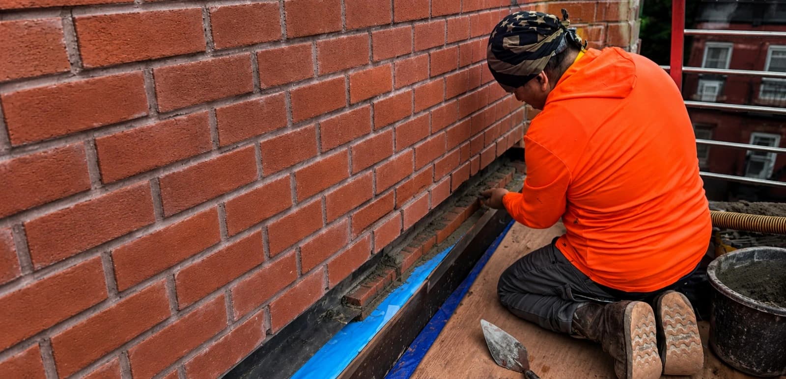 Masonry contractor repairing brickwork on a Brooklyn property